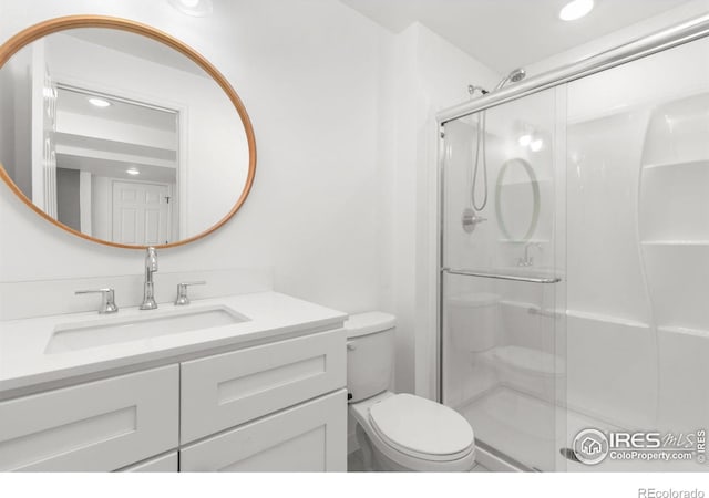 bathroom with recessed lighting, vanity, toilet, and a shower stall