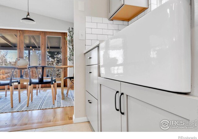 interior space featuring light countertops, tasteful backsplash, white cabinetry, and light wood-style floors