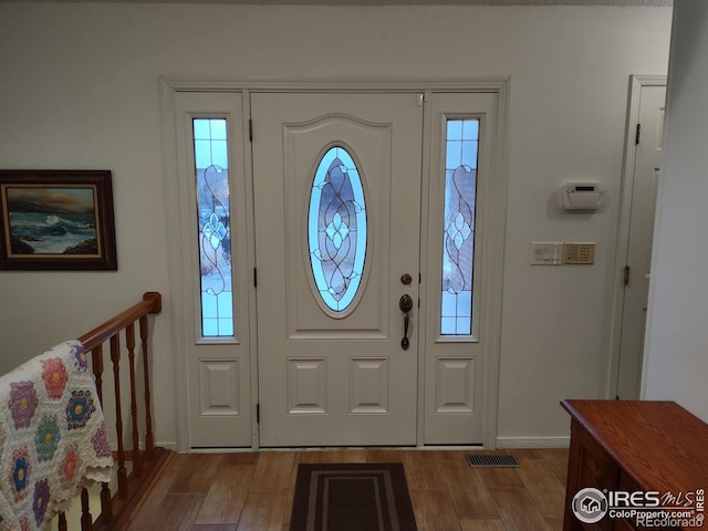entrance foyer featuring visible vents, baseboards, and wood finished floors