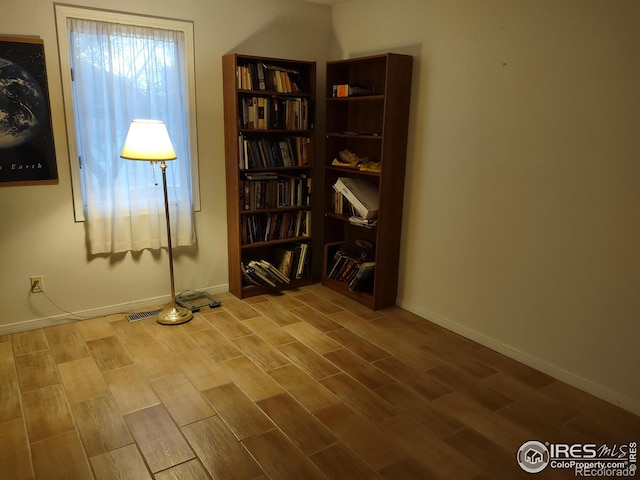 sitting room featuring visible vents, baseboards, and wood finished floors