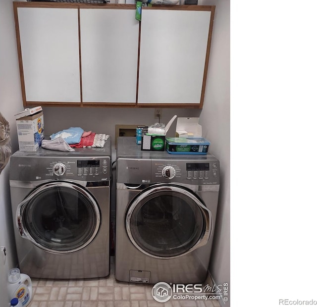 washroom with washing machine and dryer and cabinet space