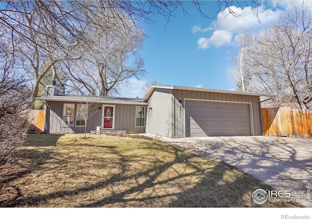 view of front of home with an attached garage, fence, concrete driveway, a chimney, and a front yard