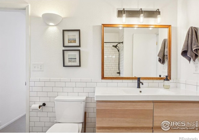 bathroom featuring toilet, tile walls, and vanity