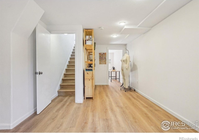 interior space featuring light wood-style floors, stairway, and baseboards