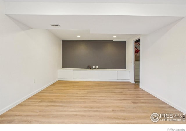 empty room with recessed lighting, wood finished floors, visible vents, and baseboards