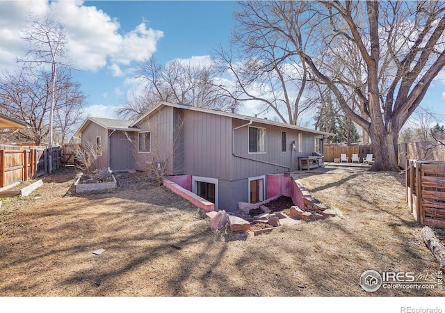 rear view of house featuring a fenced backyard