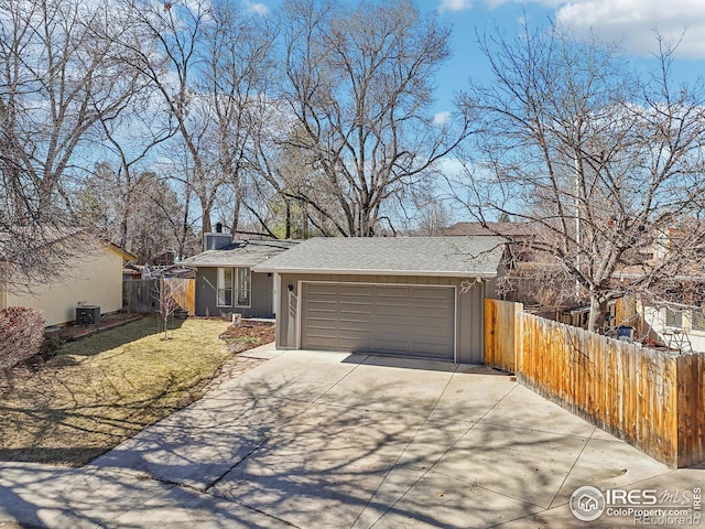 view of front of house featuring an attached garage, central air condition unit, fence, driveway, and a chimney