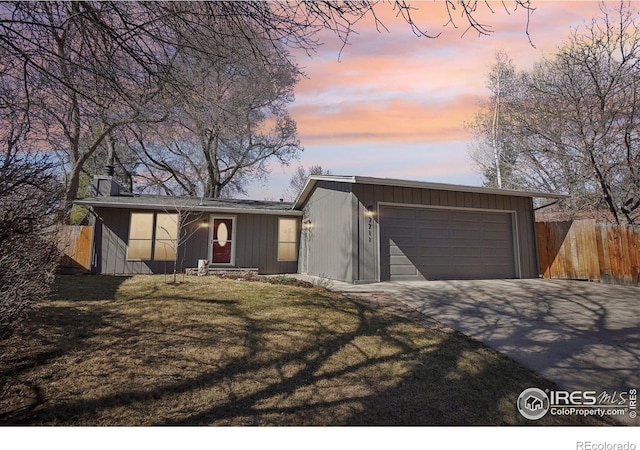 mid-century inspired home featuring a chimney, fence, and a front lawn