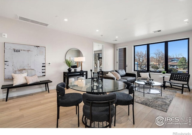 dining area with baseboards, light wood finished floors, visible vents, and recessed lighting