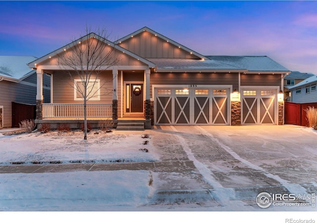 view of front of property with board and batten siding, concrete driveway, a porch, and an attached garage