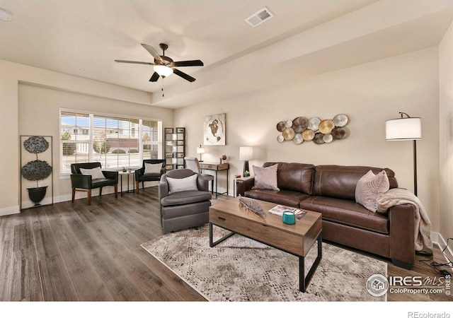 living room featuring ceiling fan, wood finished floors, visible vents, and baseboards