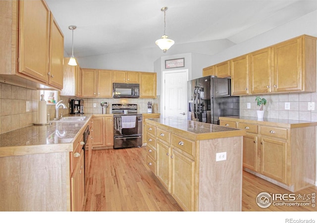 kitchen with black appliances, tile countertops, light wood finished floors, and a sink