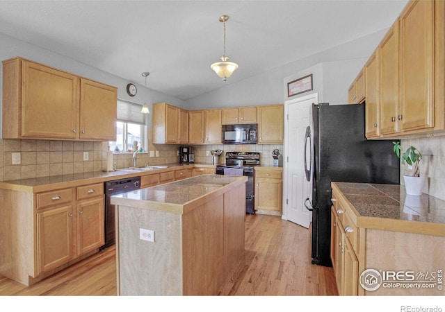 kitchen with a sink, black appliances, tile countertops, and a center island