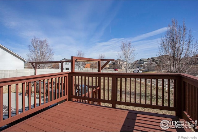 wooden terrace with a residential view and a fenced backyard