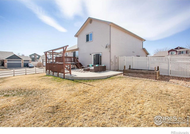 rear view of property featuring a lawn, outdoor lounge area, a fenced backyard, a deck, and a patio