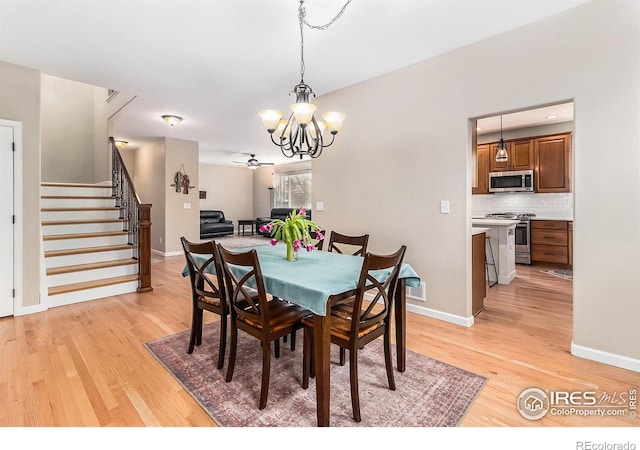 dining room with light wood-style floors, visible vents, stairway, and baseboards