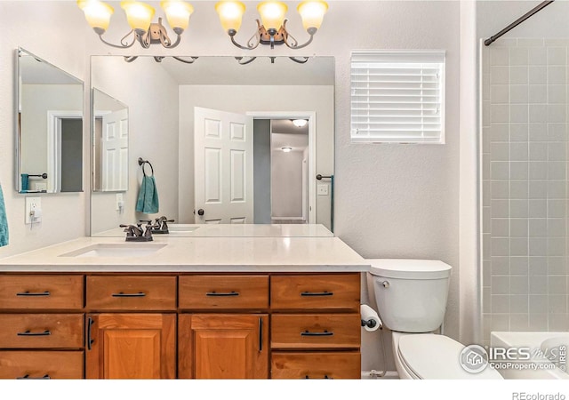 full bathroom featuring a textured wall, vanity, and toilet