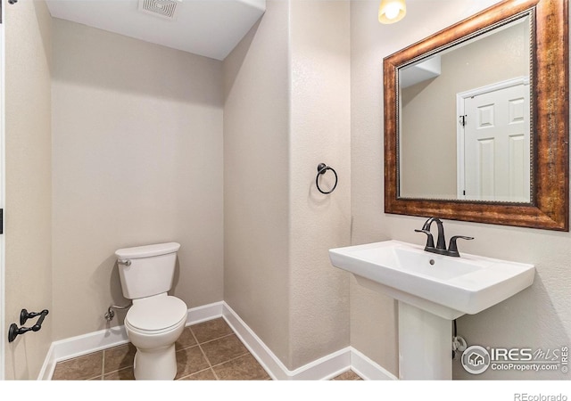 bathroom featuring baseboards, visible vents, toilet, and tile patterned floors