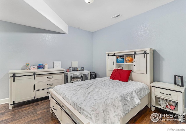 bedroom with visible vents and dark wood-type flooring