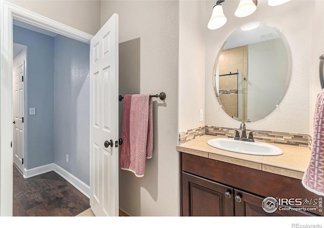 bathroom featuring vanity, baseboards, and wood finished floors