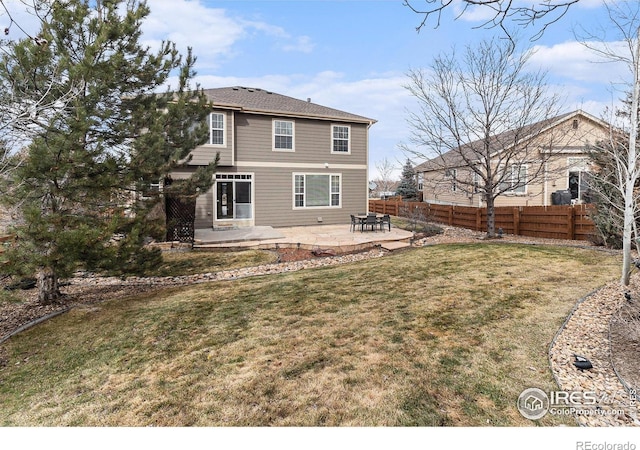 back of property with a yard, a patio area, and fence