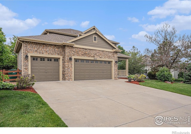 4910 Crimson Star Dr, Broomfield, CO 80023 - view of front facade featuring driveway, stone siding, an attached garage, and a shingled roof