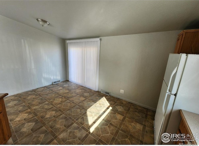 empty room featuring stone finish floor and visible vents