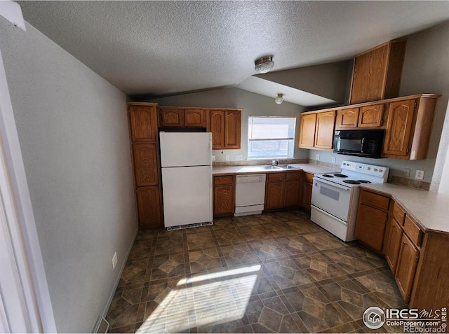 kitchen with brown cabinets, light countertops, vaulted ceiling, a sink, and white appliances