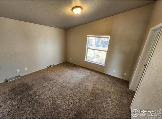 unfurnished room with visible vents, a textured wall, a textured ceiling, and carpet flooring