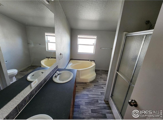 full bath with a textured ceiling, a sink, and a shower stall