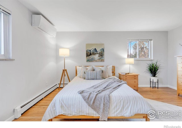 bedroom with wood finished floors, baseboards, baseboard heating, and a wall mounted AC