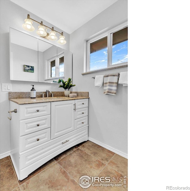 bathroom with tile patterned floors, vanity, and baseboards