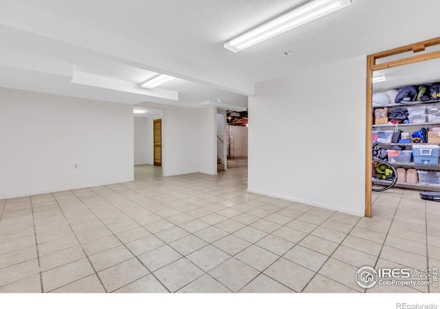 unfurnished room featuring light tile patterned floors and stairs