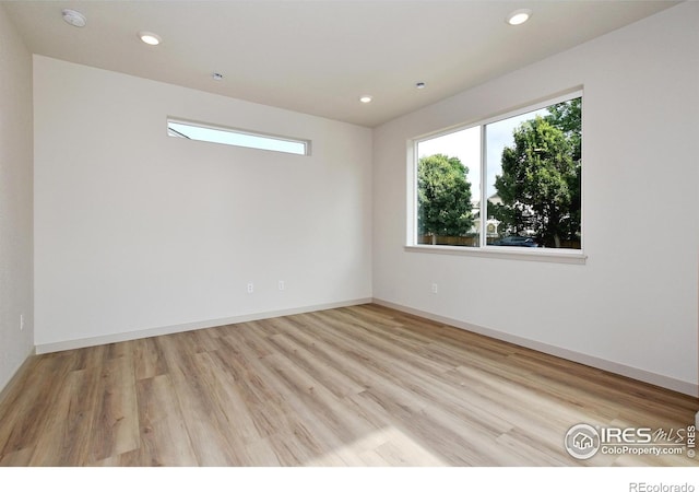 spare room featuring baseboards, wood finished floors, and recessed lighting