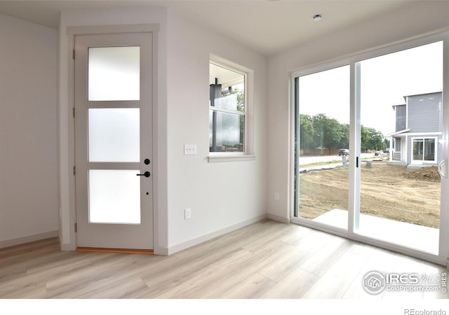 doorway featuring light wood-type flooring and baseboards