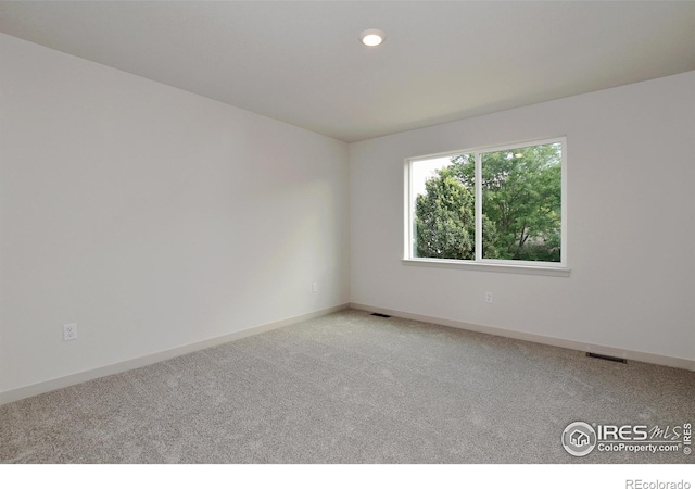 empty room featuring baseboards, recessed lighting, visible vents, and light colored carpet