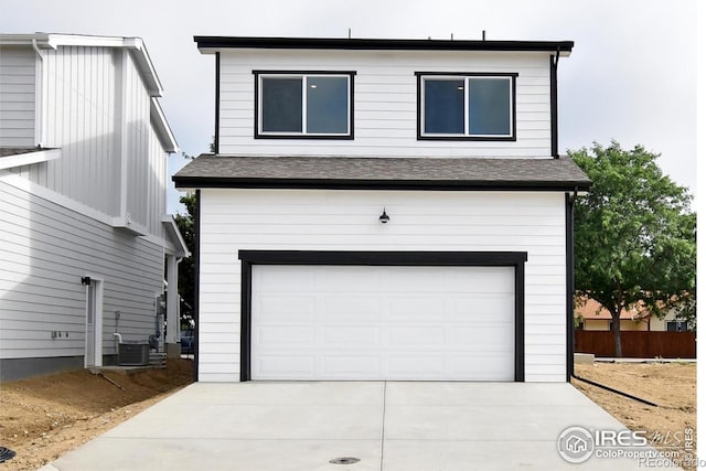 view of front facade with a garage, cooling unit, and concrete driveway