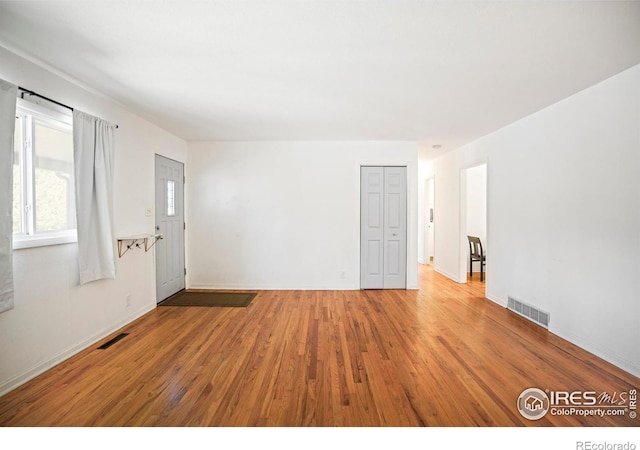 empty room featuring baseboards, visible vents, and wood finished floors