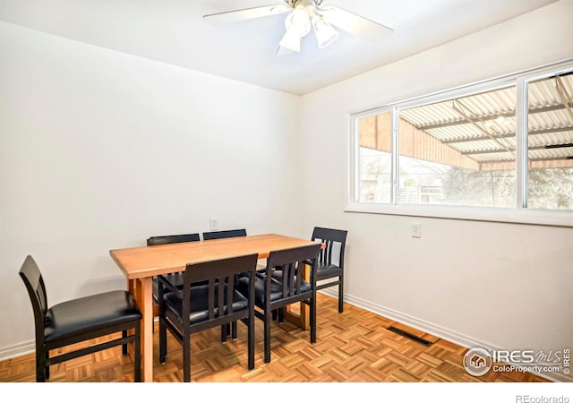 dining room with a ceiling fan, plenty of natural light, visible vents, and baseboards