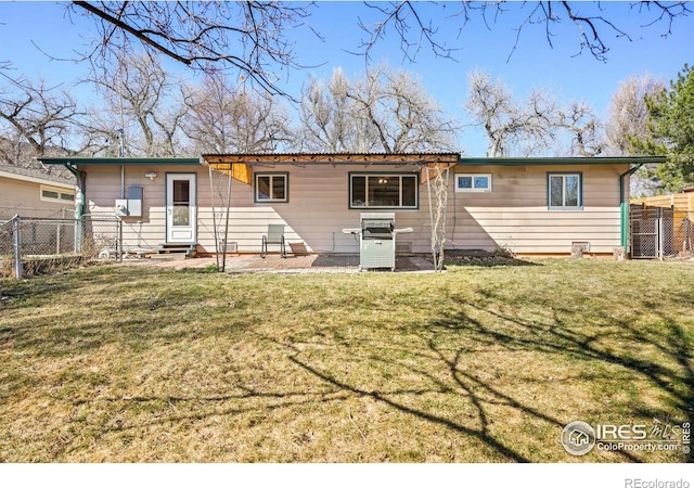 back of house with entry steps, a yard, and fence