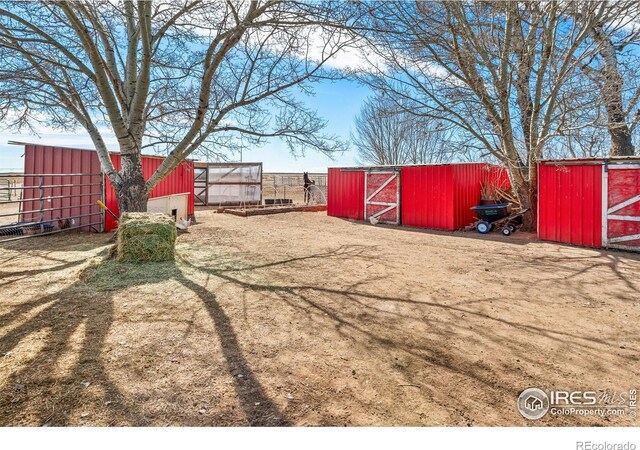 view of yard with fence, an outbuilding, and an outdoor structure