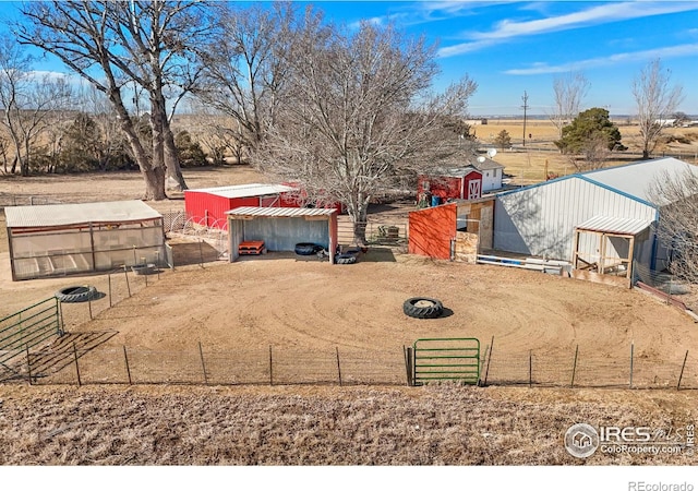 view of yard featuring an outbuilding, an outdoor structure, dirt driveway, and fence