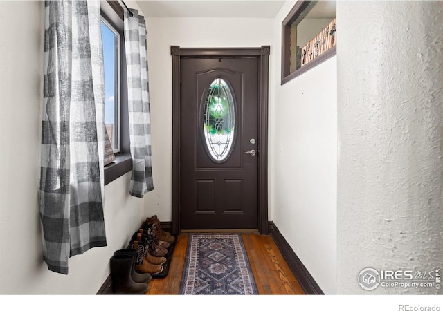 doorway featuring wood finished floors and baseboards