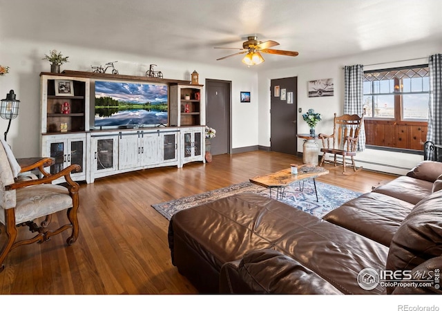 living room featuring ceiling fan, baseboard heating, and wood finished floors