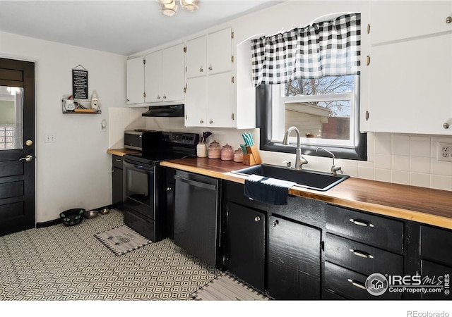 kitchen featuring dishwashing machine, butcher block counters, dark cabinets, black electric range oven, and a sink