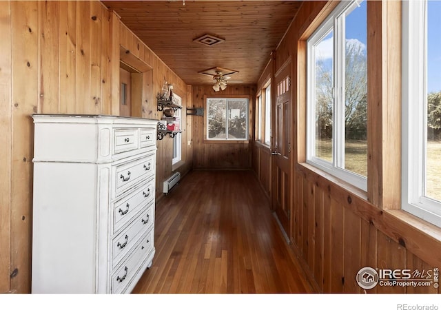 interior space with a baseboard heating unit and wooden ceiling