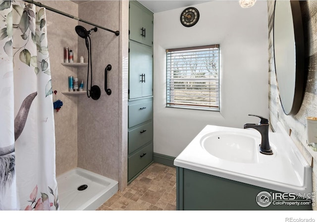 full bathroom featuring a stall shower, stone finish flooring, and vanity