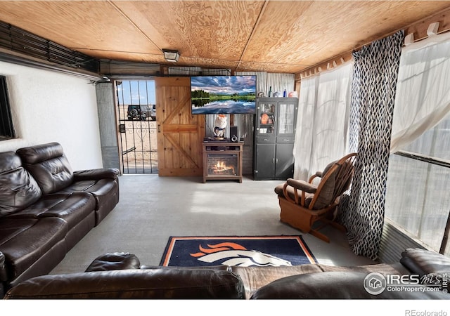 living area with wooden ceiling and concrete floors