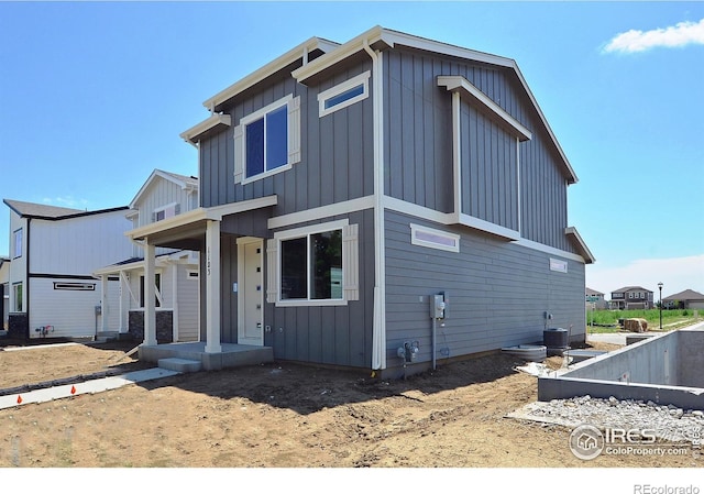 view of front of home featuring board and batten siding, central AC, and a porch