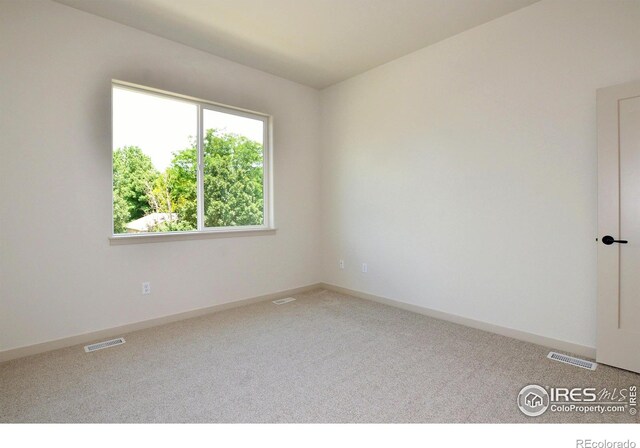 unfurnished room featuring carpet, visible vents, and baseboards